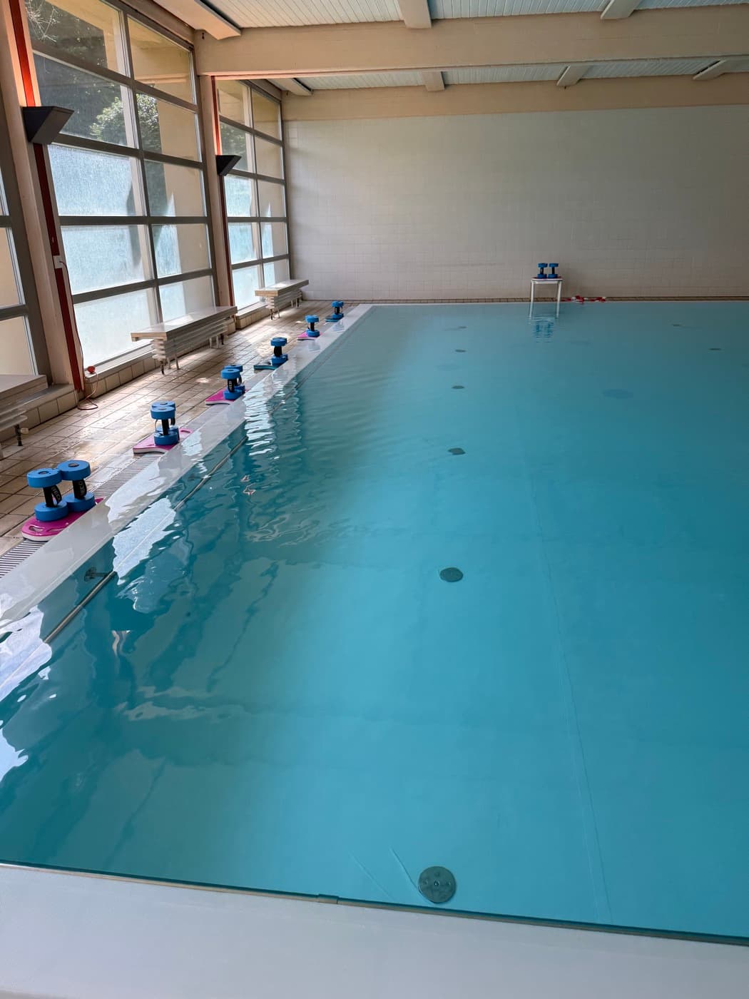 Helles Hallenbad mit pinken Schwimmplatten