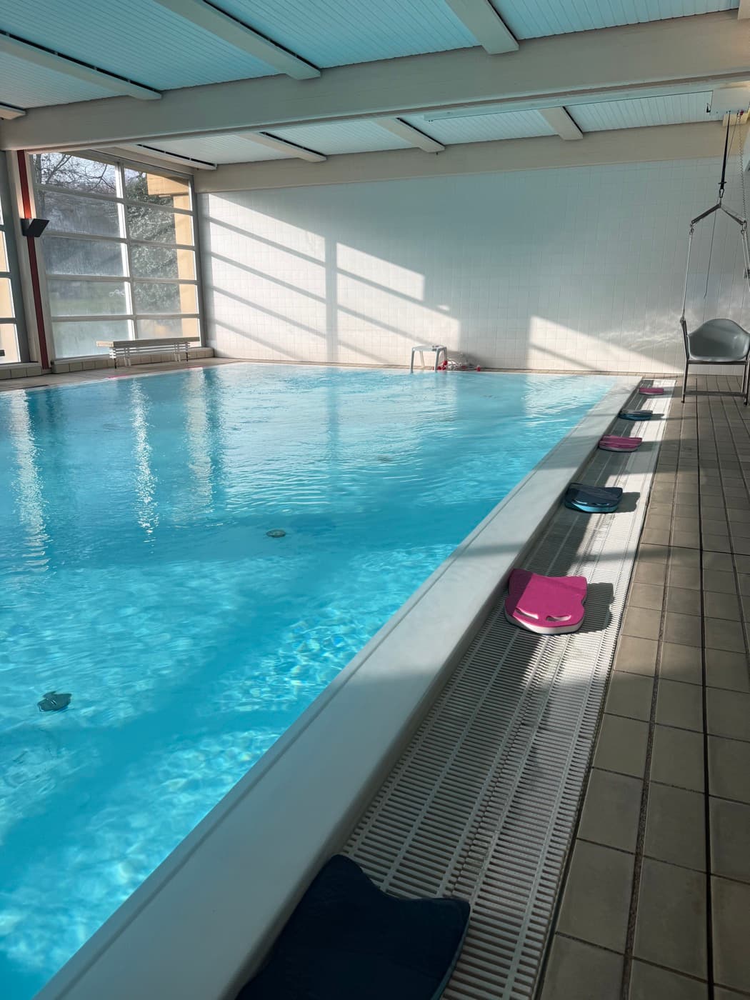 Schwimmbecken mit blauen Aqua-Hanteln und Schwimmplatten